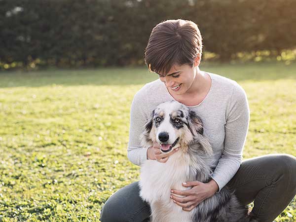 Woman with her Australian Shepherd at a park.