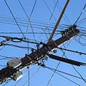 Power poles and wires against blue sky.